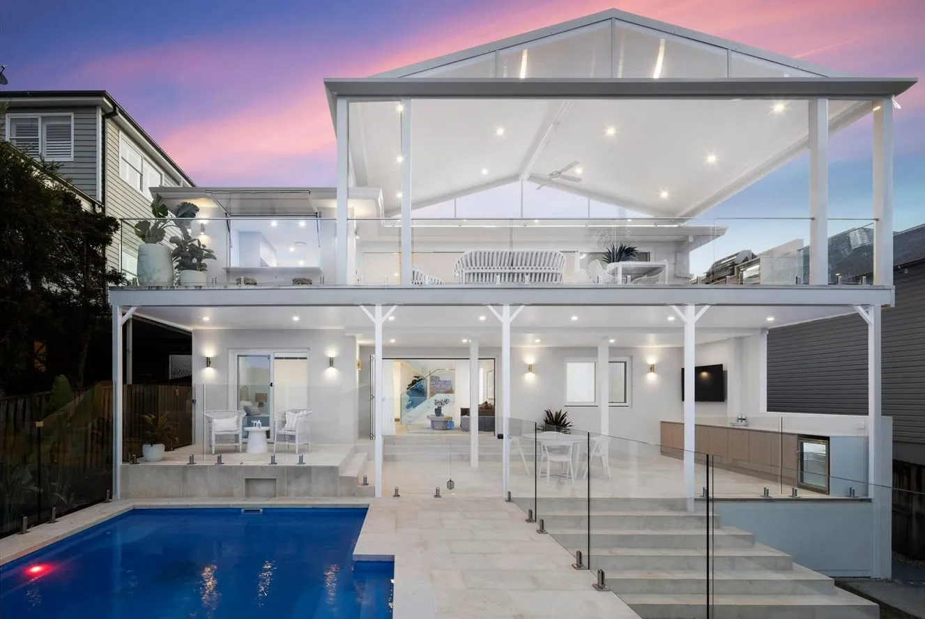 The renovated Collaroy home at dusk with pool and exterior lighting
