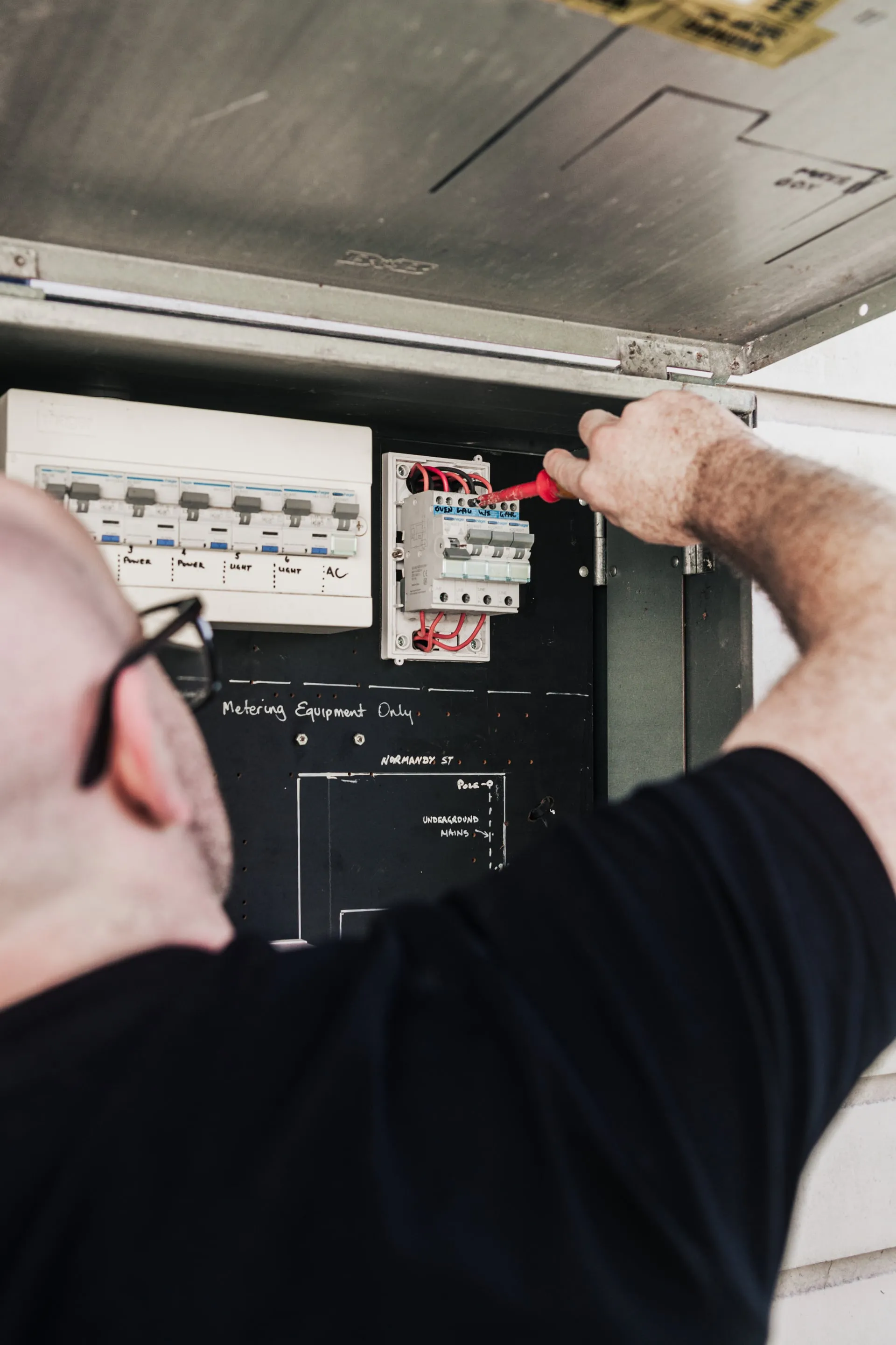 End Point Electrical electrician working inside an open switchboard